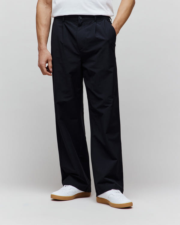 Black premium Malik Wide Leg Pant, a refined streetwear style with a relaxed, full-length fit, featuring a single front pleat and smooth woven fabric.