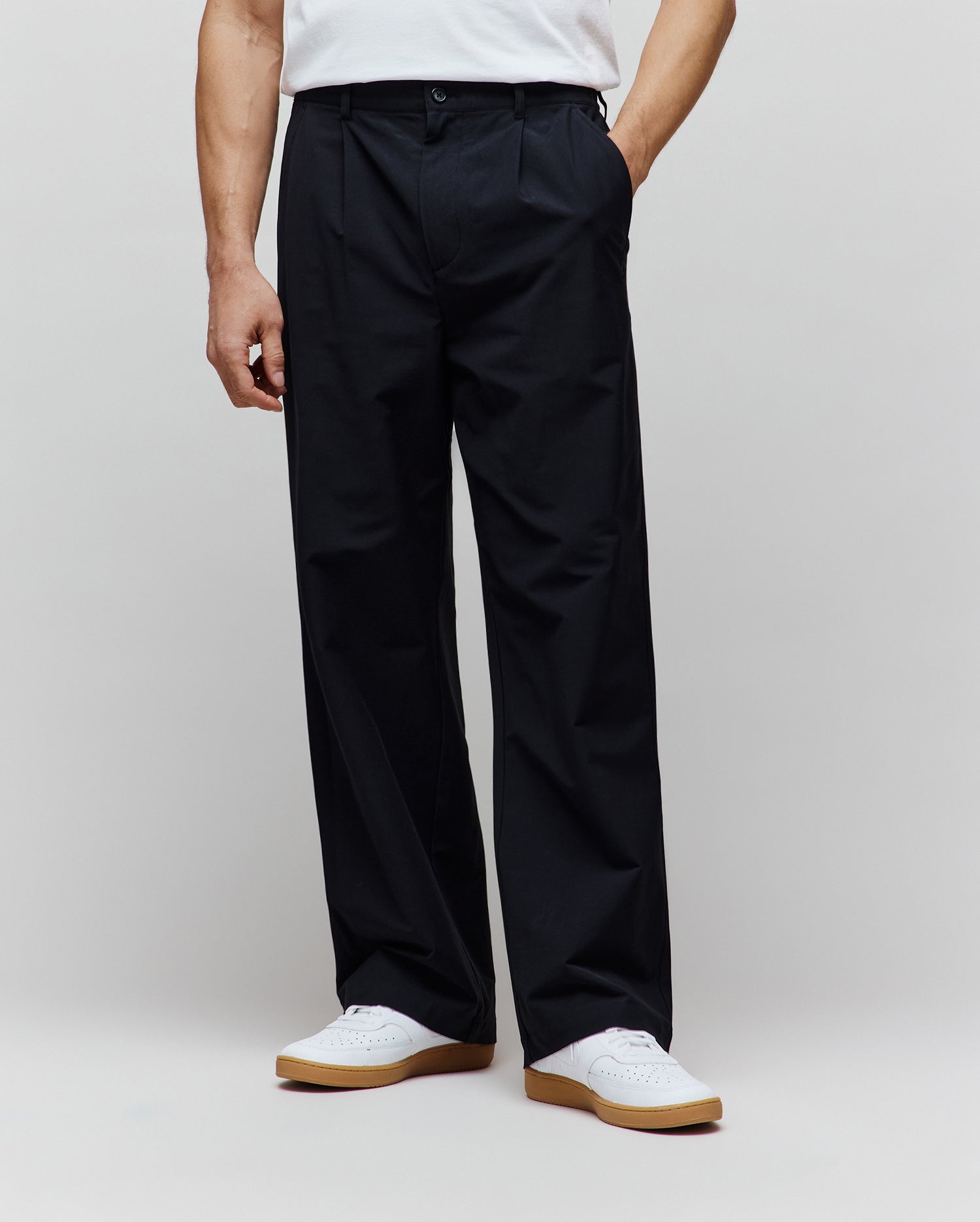 Black premium Malik Wide Leg Pant, a refined streetwear style with a relaxed, full-length fit, featuring a single front pleat and smooth woven fabric.
