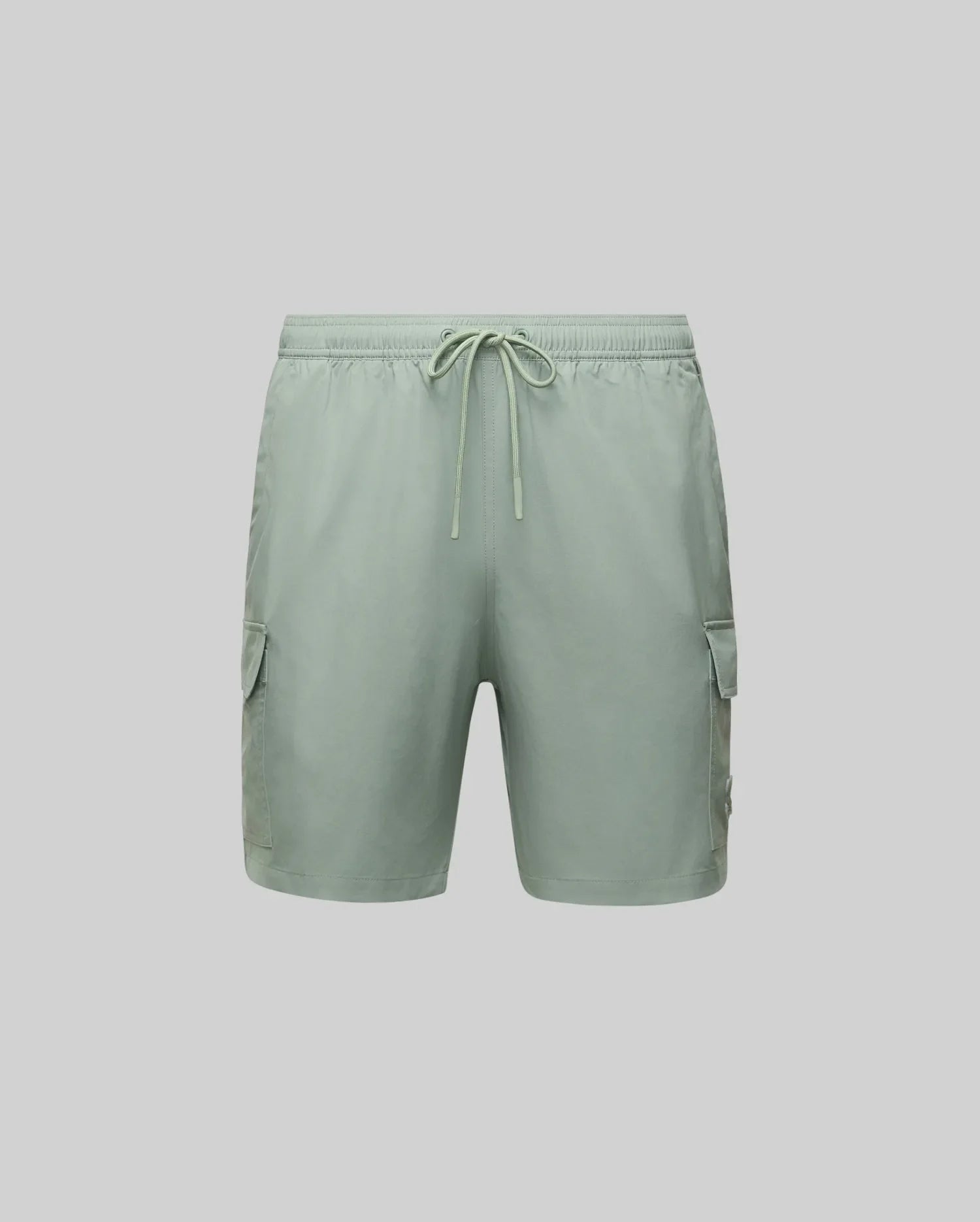 The Psycho Bunny MENS RANDY BOARD SWIM SHORT (MB1000002) in light green features an elastic waistband, drawstring, and two side cargo pockets—ideal for a relaxed beach day. Shown on a plain light grey background.