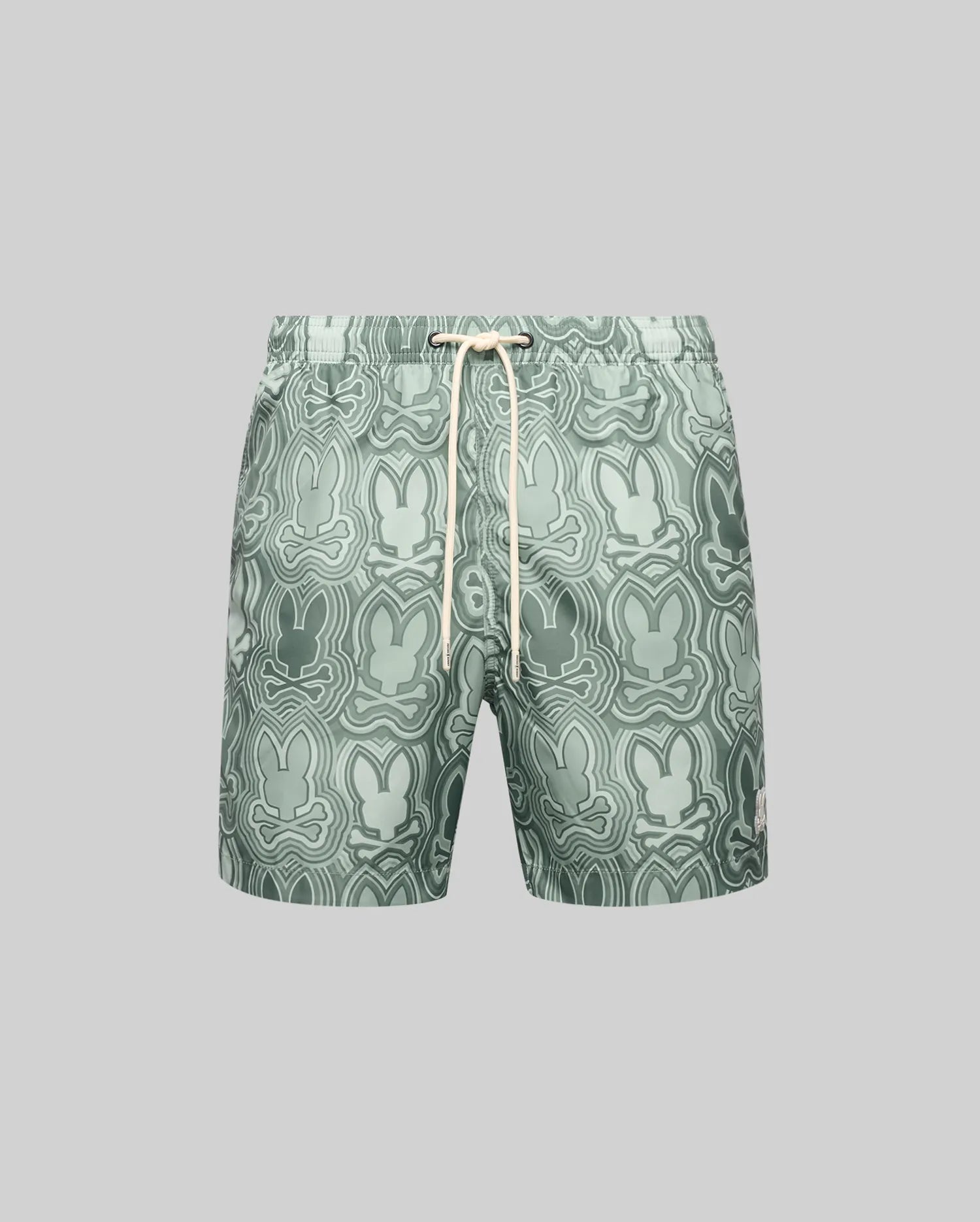 The Psycho Bunny MENS CHUCK ALL OVER PRINT LIGHTWEIGHT SWIM TRUNK (MB1000003) features an abstract green bunny pattern, quick-dry recycled polyester fabric, and a white drawstring waist, shown on a plain gray background.