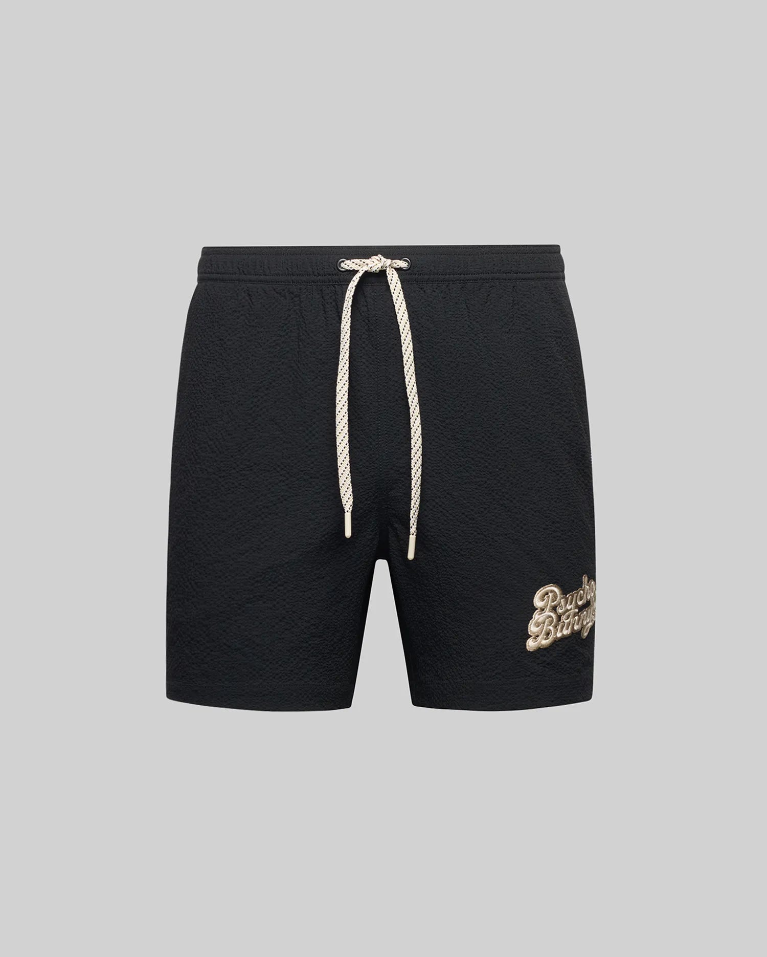 The Psycho Bunny MENS ELIAS SWIM TRUNK (MB1000008) features a classic fit, white drawstring, and beige cursive logo on the left leg, inspired by gym shorts and shown on a plain gray background.