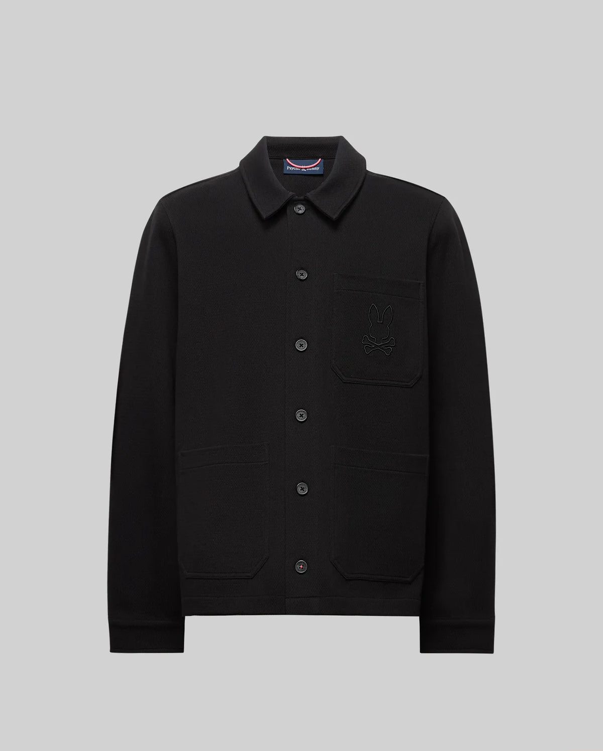 The Psycho Bunny MENS AVEN KNIT SHACKET (MO1100035) is a black knit shacket with a stylish cat design, offering transitional comfort and effortless layering.