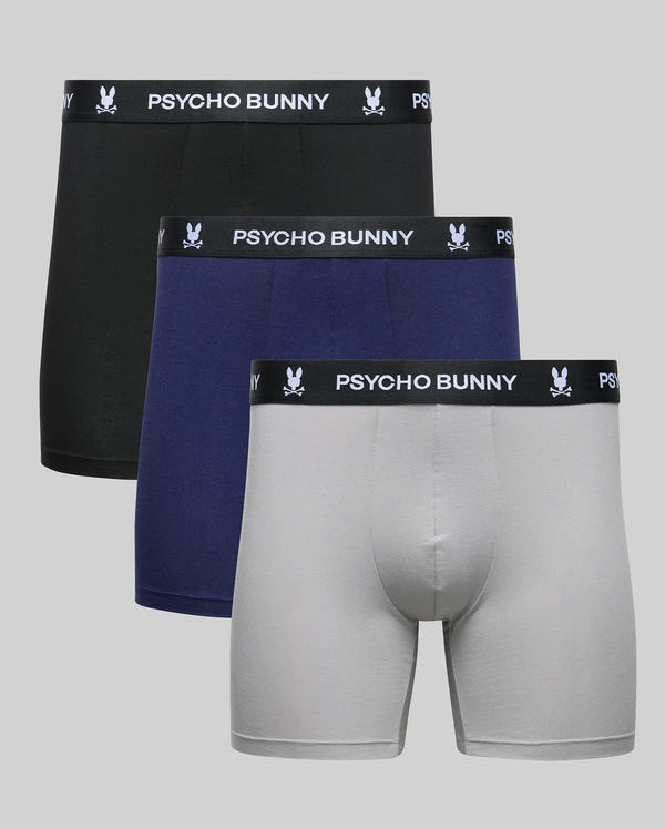 The Psycho Bunny MENS 3 PACK BOXER BRIEF - MO1400006 includes three men's boxer briefs in black, navy blue, and light gray, made of a soft cotton-modal blend with black waistbands featuring the white brand name and bunny logo.