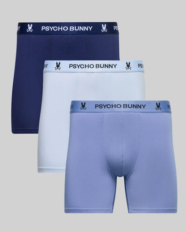 The Psycho Bunny MENS 3 PACK BOXER BRIEF (MO1400008) includes three pairs of stretch cotton men's underwear in navy, white, and light blue, each with a branded waistband featuring the Psycho Bunny logo.