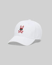 The Psycho Bunny MENS MISCHIEF BASEBALL CAP (MO1500015) is a white 100% cotton cap featuring an embroidered black and red Mischief Bunny logo—a cartoon rabbit head with crossbones—on the front panel, shown against a gray background.