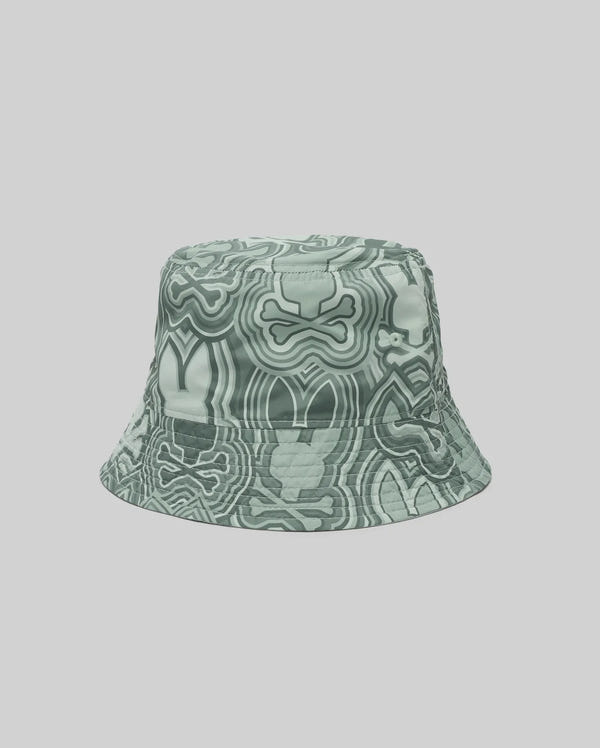 The Psycho Bunny MENS CHUCK REVERSIBLE BUCKET HAT (MO1500028) features a green and white abstract, wavy design with bone and face-like shapes—an eye-catching summer accessory set against a plain light gray background.
