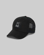 The Psycho Bunny MENS DARIO TRUCKER CAP (MO1500044) in black features breathable mesh, a curved brim, adjustable snap-back, and a front patch with a white bunny head over crossed bones, shown on a plain grey background.