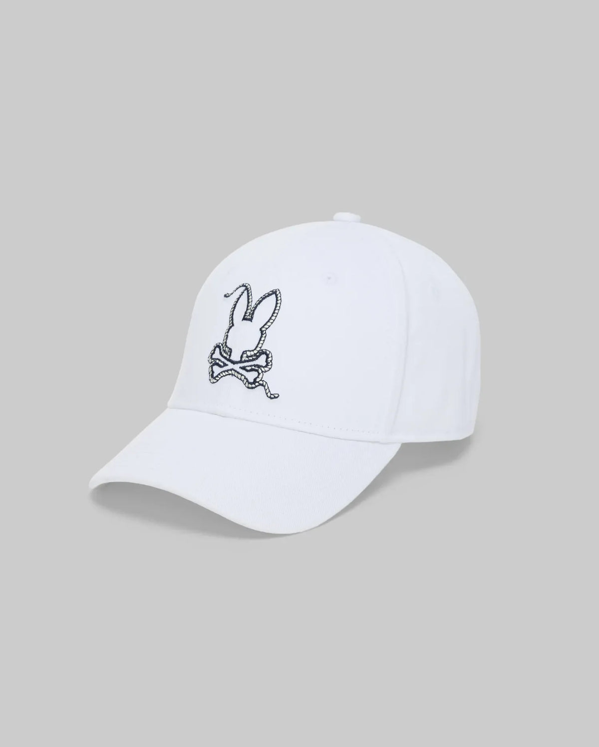 The Psycho Bunny MENS CYRUS BASEBALL CAP - MO1500045 is a white cap with an embroidered rabbit head above crossed carrots on the front, capturing coastal charm against a plain grey background.