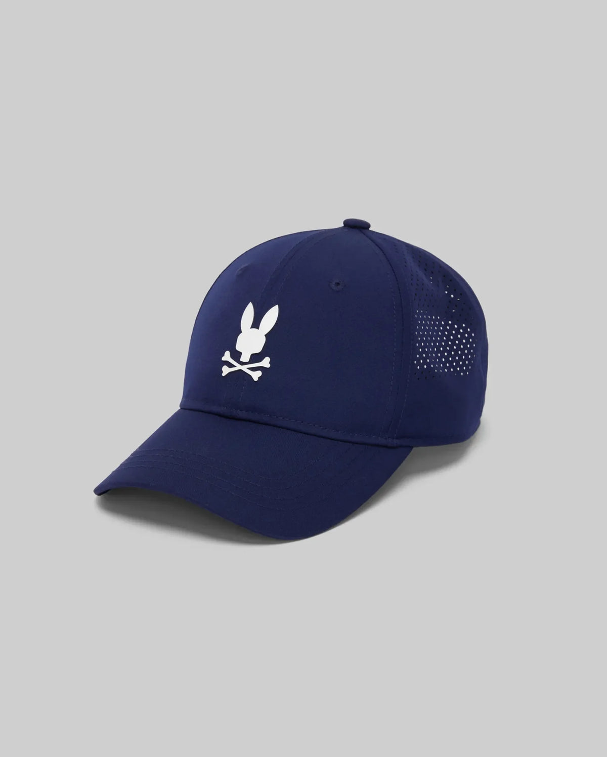 The Psycho Bunny MENS FORREST SPORT CAP (MO1500046) is a navy blue athletic cap with a white bunny head and crossbones logo, mesh ventilation panels, sweat-wicking interior, adjustable strap, shown on a light gray background.