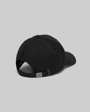 The Psycho Bunny MENS CYRUS PB BASEBALL CAP - MO1500047 in black is shown from the back, featuring a curved brim, adjustable metal-buckle strap, and a subtle rope-style logo graphic against a plain gray background.