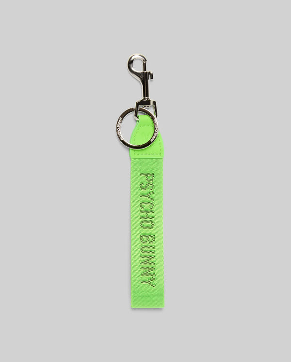 The PSYCHO BUNNY WOVEN TAPE KEYCHAIN - MO1700001 by Psycho Bunny features sleek neon green fabric with "PSYCHO BUNNY" in white, plus a durable metal keyring and clasp. Photographed on a light gray background.