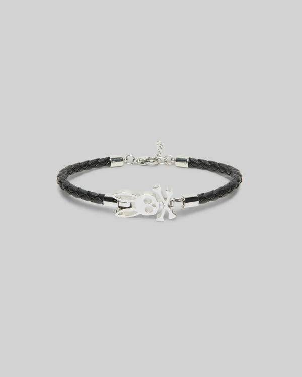 The Psycho Bunny MENS LEATHER BUNNY BRACELET - MO1700024 features black braided leather, a silver clasp, and a central silver bunny charm, shown on a plain light gray background—perfect for everyday wear.