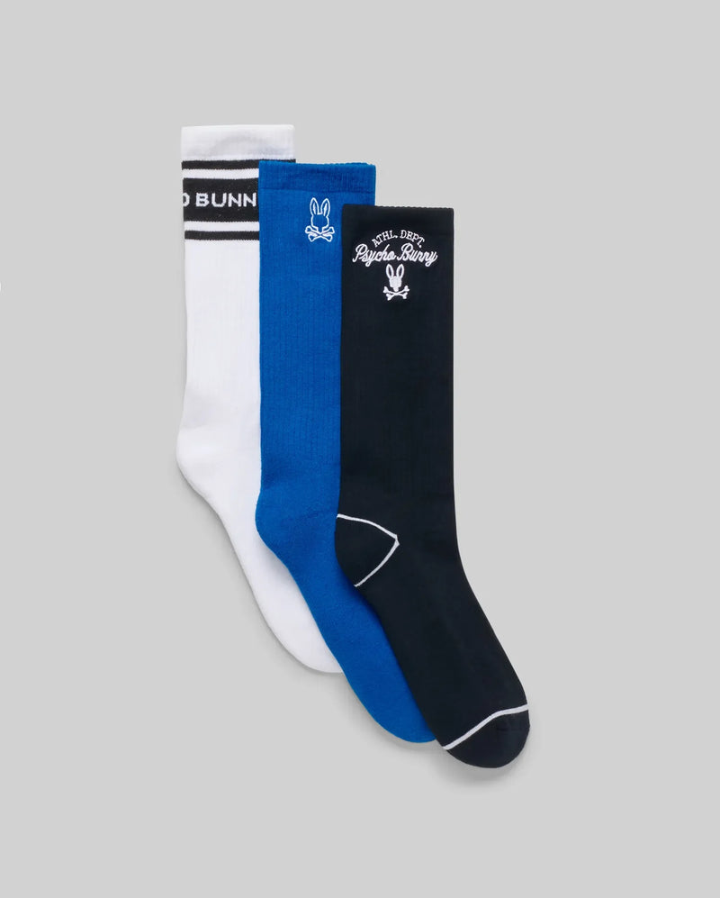 The Psycho Bunny MENS 3 PACK SPORT SOCK (MO2200006) includes white, blue, and black Pima cotton crew socks with unique vintage-inspired designs, shown side by side on a plain gray background.