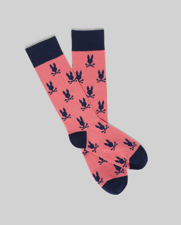 The Psycho Bunny MENS ALL OVER BUNNY DRESS SOCK - MO2200022 is a pair of pink Pima cotton socks with navy blue toes, heels, and cuffs, detailed with a repeating pattern of navy blue bunnies.