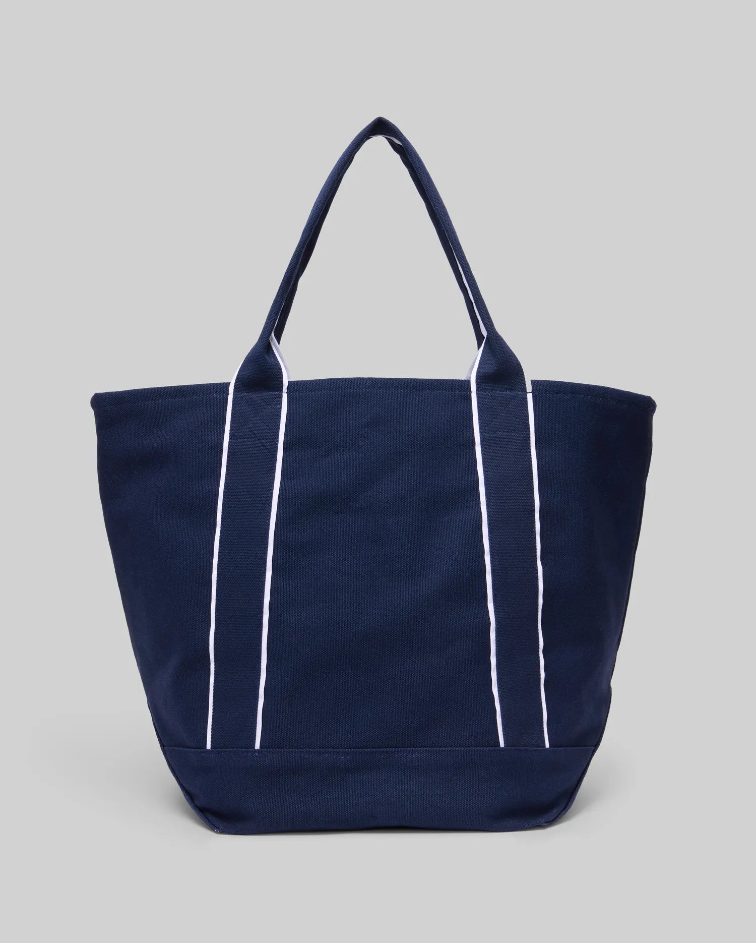 The Psycho Bunny MENS CANVAS TOTE BAG - MO2400016 is a navy tote with two handles and vertical white stripes, built for function, shown on a light gray background.
