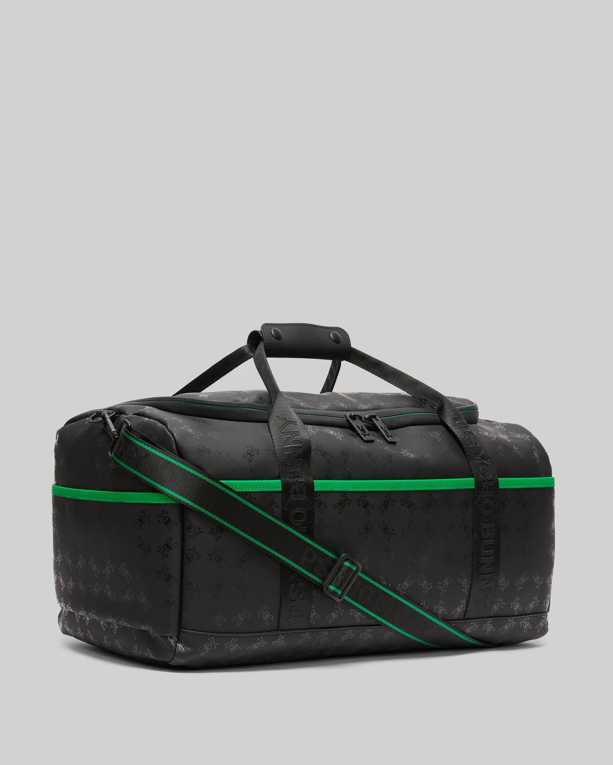 Black Gym Bag with all-over tonal bunny skull logo print, vibrant green accent stripe, and black webbed straps featuring green detail and Psycho Bunny text branding.