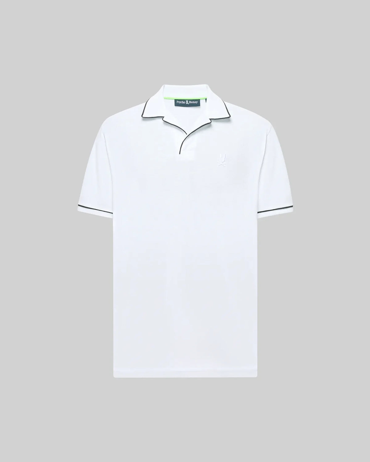 The Psycho Bunny MENS JAXON SOFT PIQUE CAMP COLLAR POLO (MT0100006) is a white short-sleeve shirt in soft piqué knit, featuring a black-piped collar and subtle chest logo, shown on a light grey backdrop.