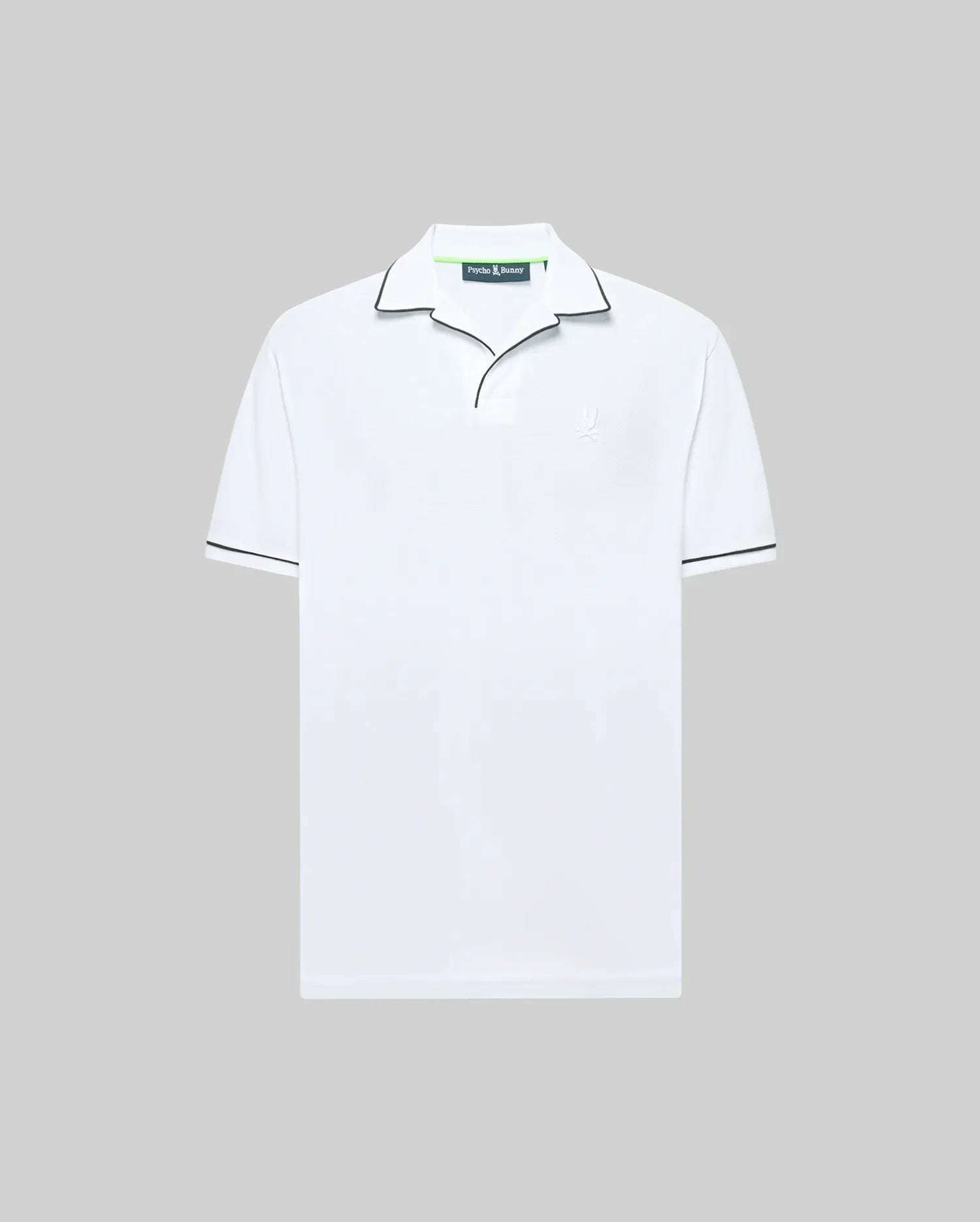 The Psycho Bunny MENS JAXON SOFT PIQUE CAMP COLLAR POLO (MT0100006) is a white short-sleeve shirt in soft piqué knit, featuring a black-piped collar and subtle chest logo, shown on a light grey backdrop.
