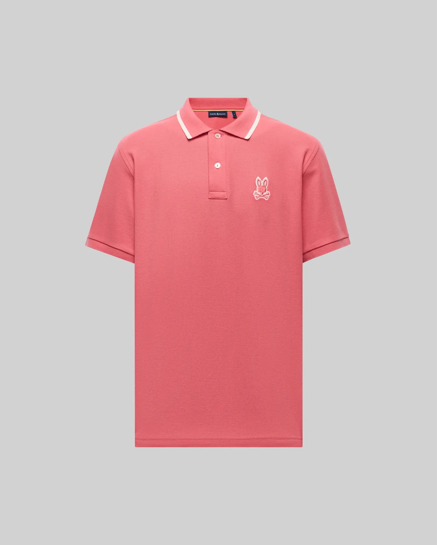 The Psycho Bunny MENS FENLEY PIQUE POLO (MT0100009) offers ultra-soft Pima cotton in pink with a white-trimmed collar and an embroidered Bunny logo on the chest, shown against a plain gray background.