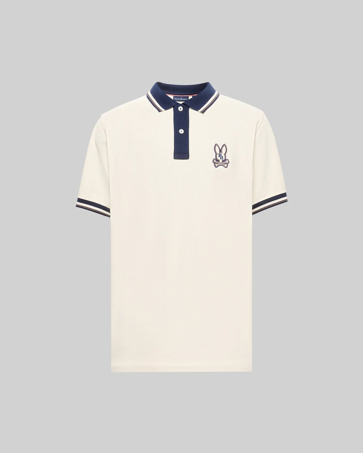 The Psycho Bunny MENS WADE PIQUE POLO (MT0100044) is a white colorblock polo with navy blue collar and sleeve cuffs, plus an embroidered bunny patch on the left chest.