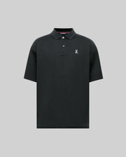 The MENS HENRY OVERSIZED FIT POLO - MT0100104 by Psycho Bunny is a black, short-sleeve Pima cotton polo with a collar, two buttons, and a small white embroidered bunny with crossed bones on the left chest. Displayed on a gray background.