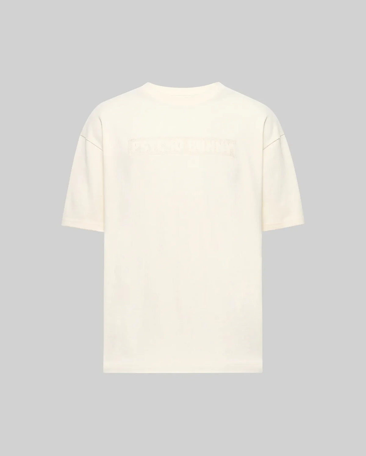 Back view of the Psycho Bunny MENS ZAYN OVERSIZED GRAPHIC TEE (MT0200004) in off-white, relaxed fit and heavyweight jersey, featuring subtle embossed text across the upper back against a light gray background.