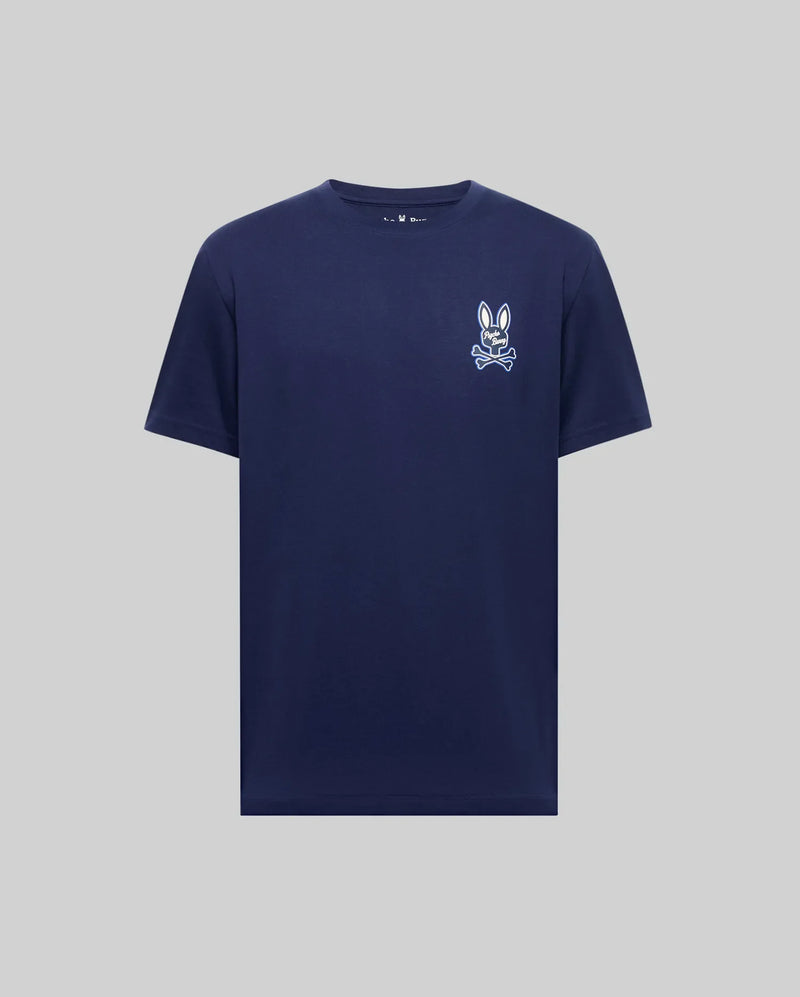 The Psycho Bunny MENS DEREK CHEST GRAPHIC TEE (MT0200009) is a navy Pima cotton crewneck with a small white bunny face and bow tie graphic on the left chest, shown against a light gray background.
