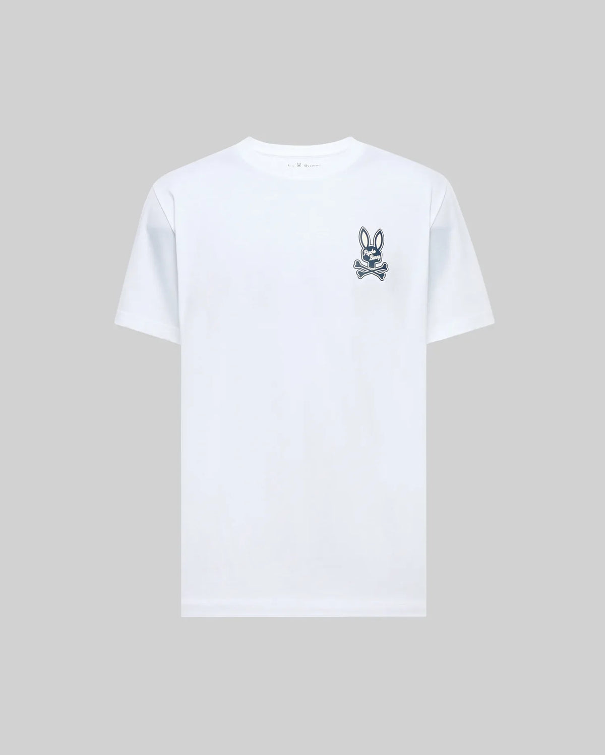 The Psycho Bunny MENS DEREK CHEST GRAPHIC TEE (MT0200009) is a regular fit, plain white short-sleeve Pima cotton t-shirt with a small black bunny skull and crossbones graphic on the left chest, displayed on a light gray background.