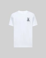 The Psycho Bunny MENS DEREK CHEST GRAPHIC TEE (MT0200009) is a regular fit, plain white short-sleeve Pima cotton t-shirt with a small black bunny skull and crossbones graphic on the left chest, displayed on a light gray background.