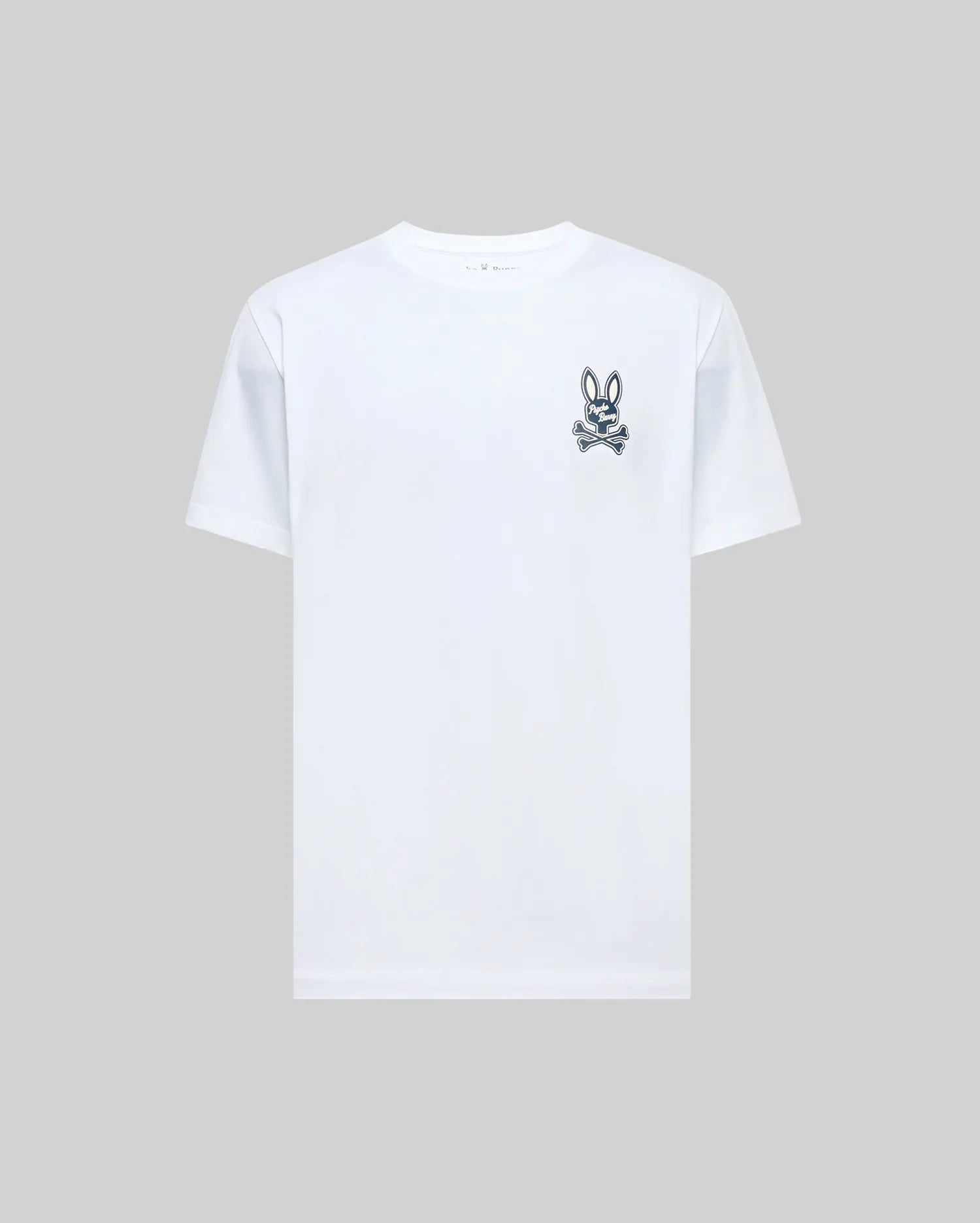 The Psycho Bunny MENS DEREK CHEST GRAPHIC TEE (MT0200009) is a regular fit, plain white short-sleeve Pima cotton t-shirt with a small black bunny skull and crossbones graphic on the left chest, displayed on a light gray background.
