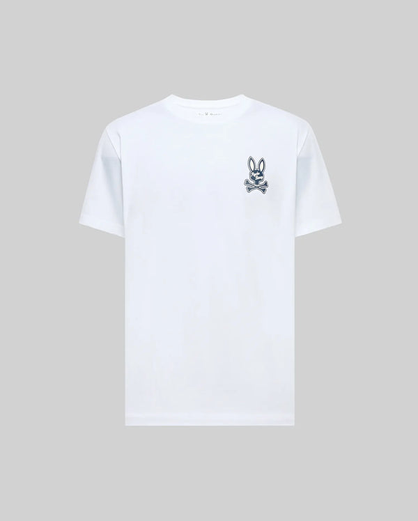 The Psycho Bunny MENS DEREK CHEST GRAPHIC TEE (MT0200009) is a regular fit, plain white short-sleeve Pima cotton t-shirt with a small black bunny skull and crossbones graphic on the left chest, displayed on a light gray background.