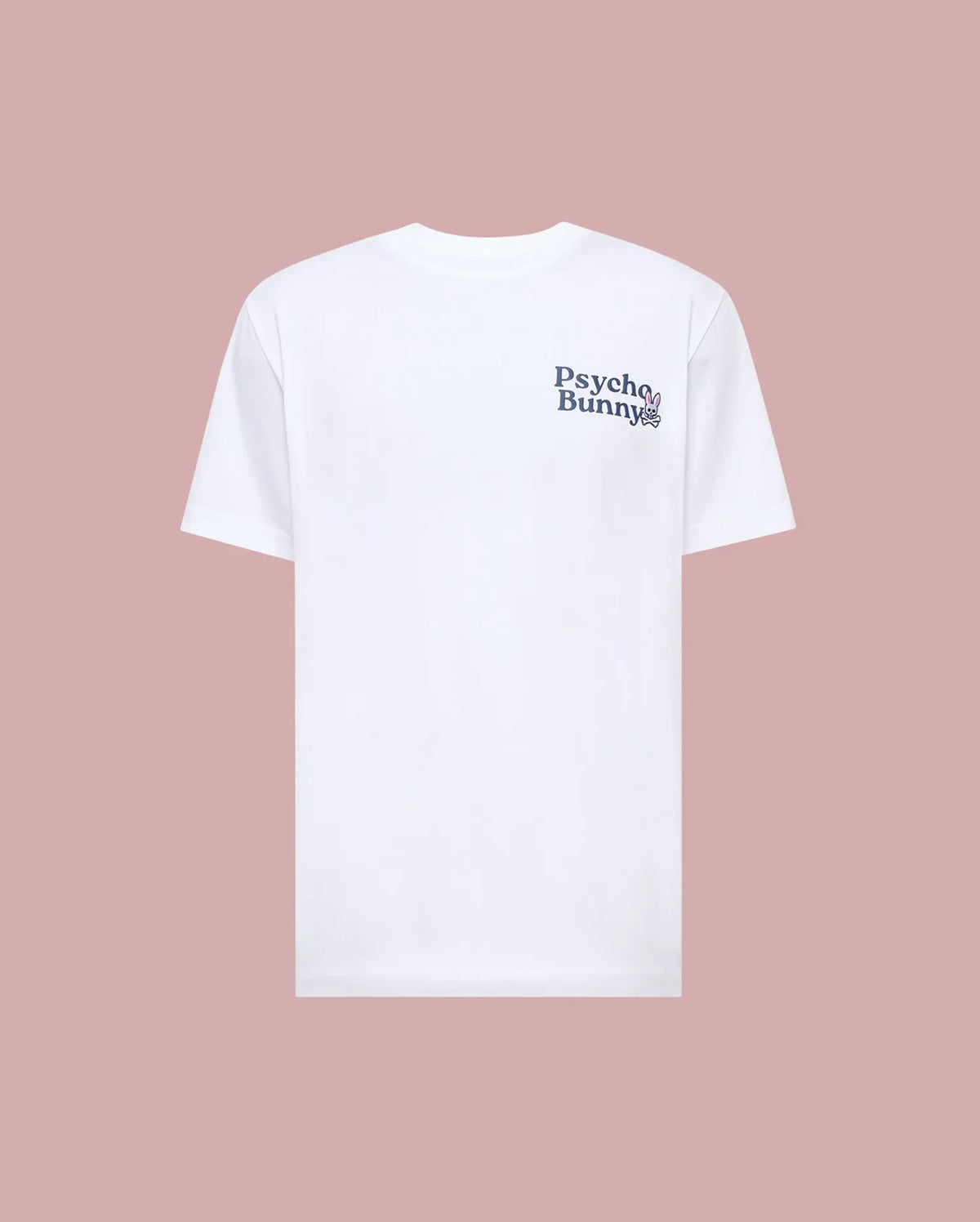 The MENS ARCHIVE WORDMARK GRAPHIC TEE - MT0200030 by Psycho Bunny is a regular fit white short-sleeve tee, shown on a pink background, with the Psycho Bunny wordmark and bunny logo in dark print on the left chest.