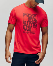 A man in a black cap and the Psycho Bunny MENS GLENN GRAPHIC TEE - MT0200034, made from 100% Pima cotton and featuring a bold Bunny print, stands against a plain light background with his head slightly turned down and to the side.