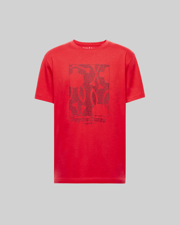 The MENS GLENN GRAPHIC TEE - MT0200034 by Psycho Bunny is a red, 100% Pima cotton short-sleeve tee featuring a rectangular abstract Bunny graphic and "Psycho Bunny" text on the front, shown against a plain gray background.
