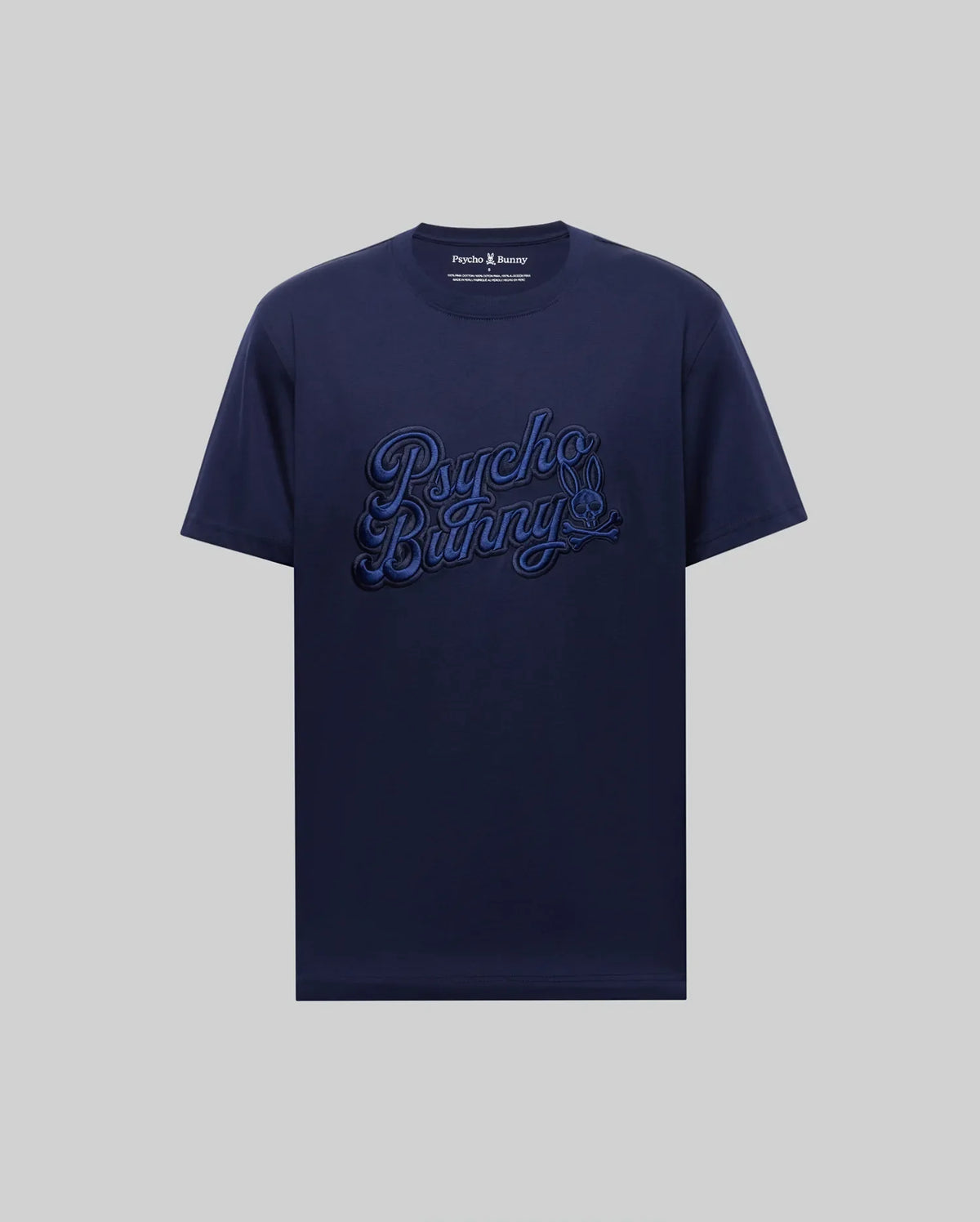 The MENS ELIAS GRAPHIC TEE - MT0200047 by Psycho Bunny is a navy blue Pima cotton short-sleeve shirt, featuring a bold bunny graphic and large "Psycho Bunny" script on the front against a plain light gray background.