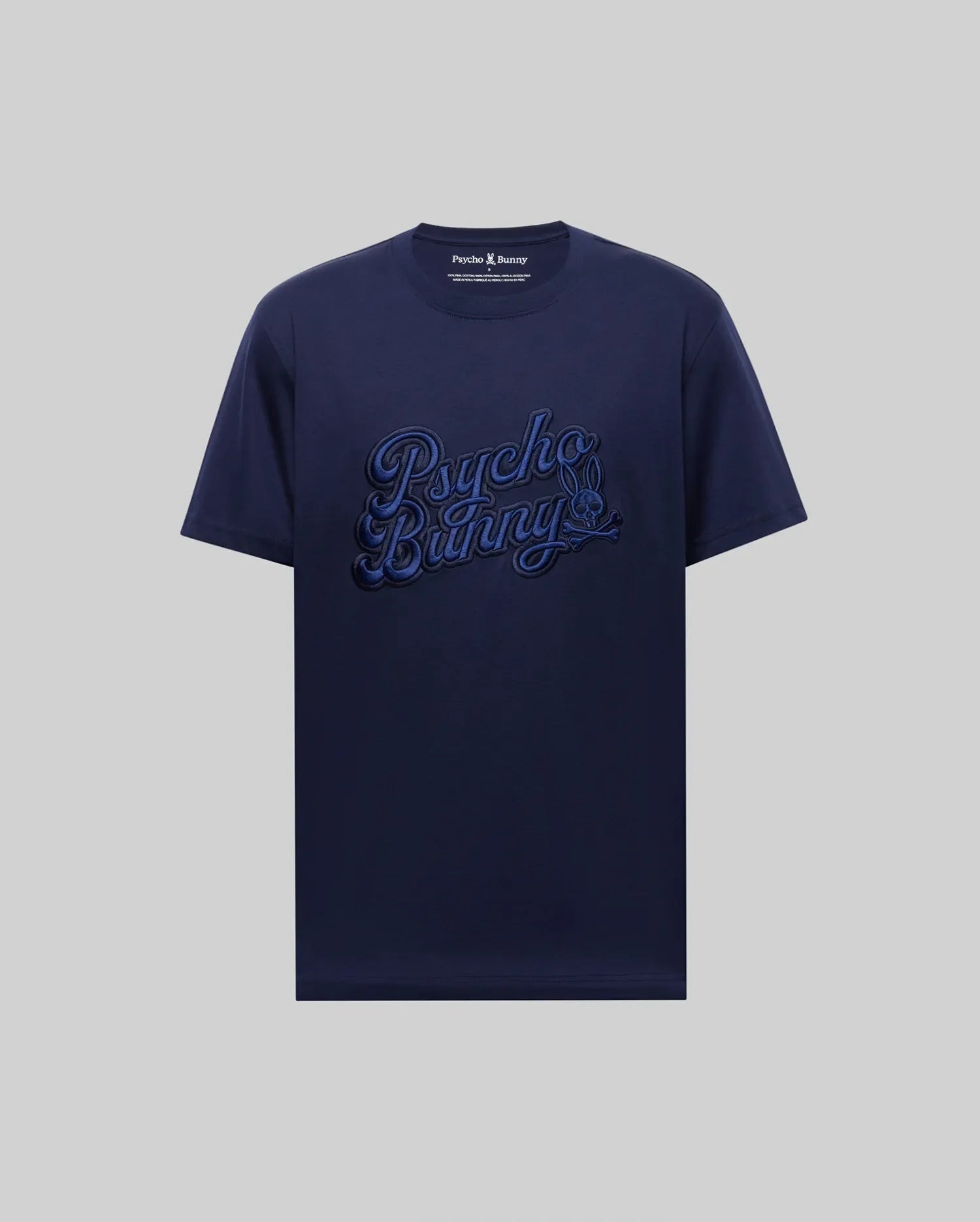 The MENS ELIAS GRAPHIC TEE - MT0200047 by Psycho Bunny is a navy blue Pima cotton short-sleeve shirt, featuring a bold bunny graphic and large "Psycho Bunny" script on the front against a plain light gray background.