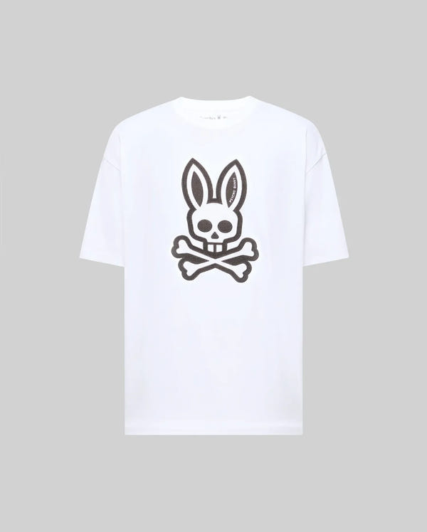 The Psycho Bunny MENS RYDER OVERSIZED FIT TEE (MT0200062) is a premium white Pima cotton T-shirt with an oversized fit, featuring a large black bunny skull and crossbones graphic on the front.
