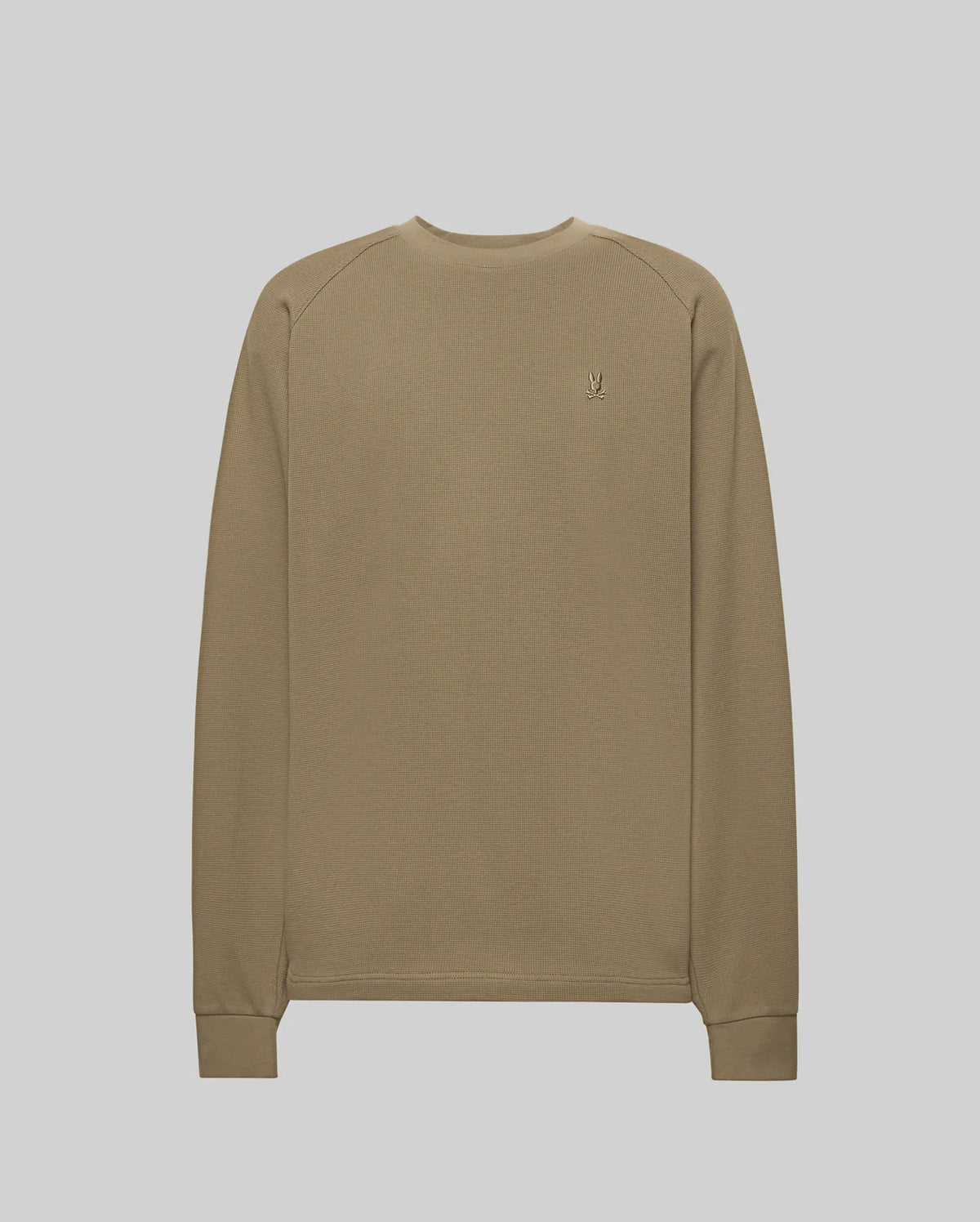 The Psycho Bunny MENS EVANS WAFFLE (MT0200091) features a plain, long-sleeved, light brown cotton knit crew neck, ribbed cuffs, and a small embroidered Bunny logo on the left chest, shown against a plain light background.