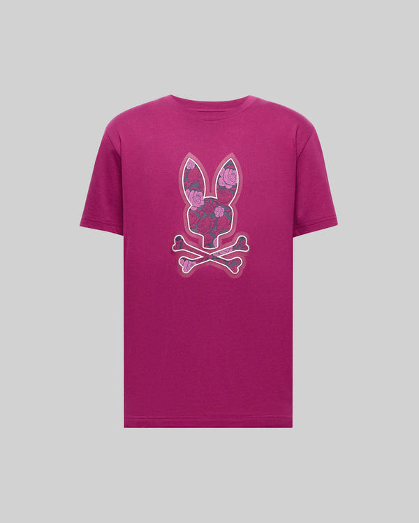 The Psycho Bunny MENS ROWEN BUNNY GRAPHIC TEE (MT0200101) is a magenta Pima cotton tee featuring a bold floral-patterned bunny head above crossed bones, displayed on a simple gray backdrop.