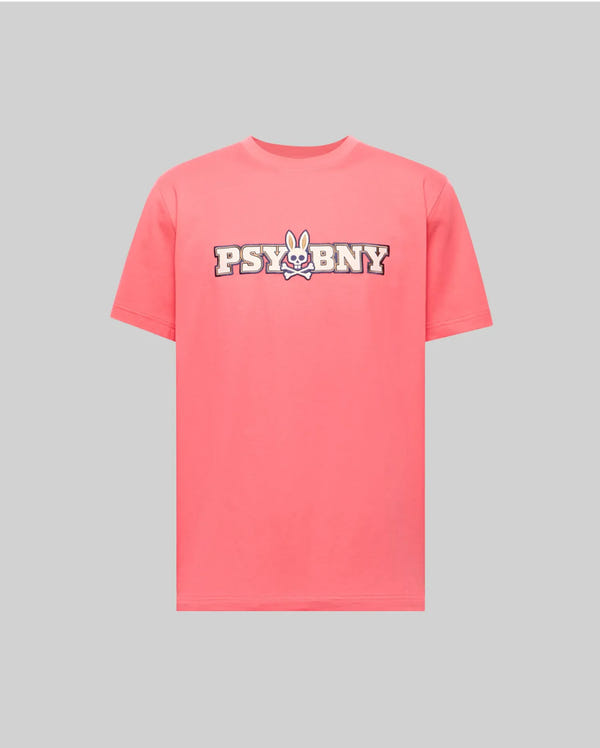 The Psycho Bunny MENS WADE GRAPHIC TEE (MT0200105) is a 100% cotton pink regular-fit shirt, featuring "PSYBNY" with a cartoon bunny face for the "U," shown on a plain gray background.