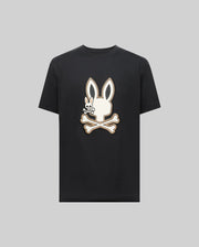 The Psycho Bunny MENS WADE GRAPHIC TEE (MT0200106) is a black 100% cotton shirt featuring a large white bunny head with crossbones on the front, shown against a plain gray background.
