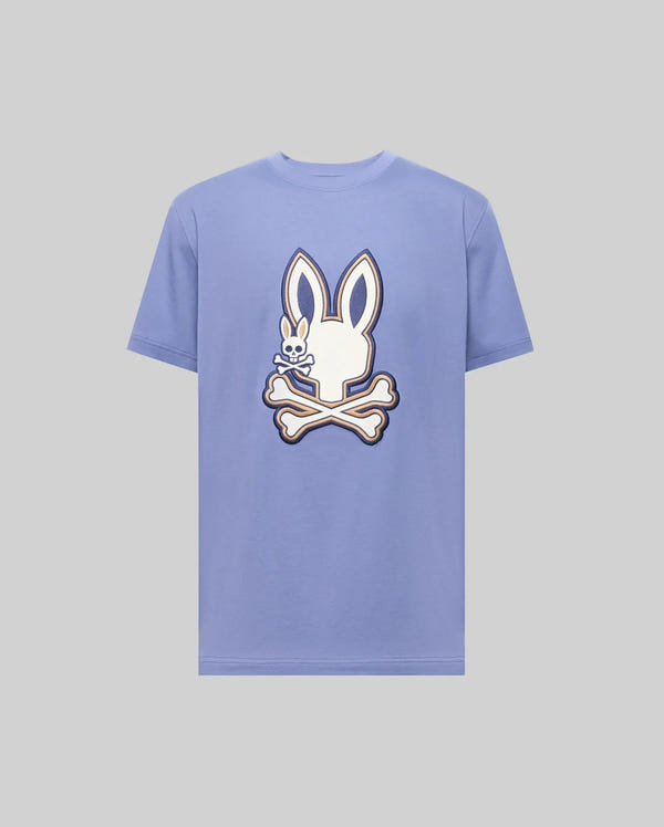 The Psycho Bunny MENS WADE GRAPHIC TEE (MT0200106) is a light purple 100% cotton shirt featuring a large white cartoon bunny head with crossbones on the front.