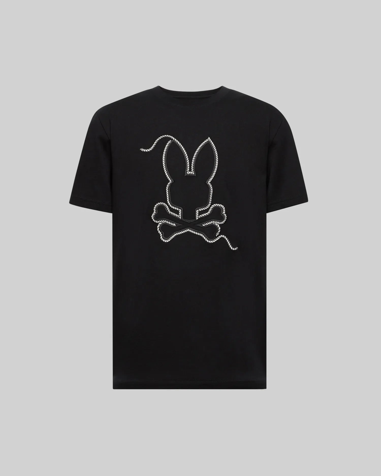 The MENS CYRUS GRAPHIC TEE - MT0200115 by Psycho Bunny is made from 100% Pima cotton, featuring a large outlined bunny head above crossed bones in a rope design on the back, echoing a sailor’s vibe, shown on a plain gray background.