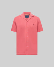 The PsychoBunny MENS JAYME KNIT SEERSUCKER CABANA COLLAR SHIRT (MT0300002) is a short-sleeved, button-up in coral pink with a cabana collar and embroidered logo, crafted from a premium cotton blend and shown on a light grey background.