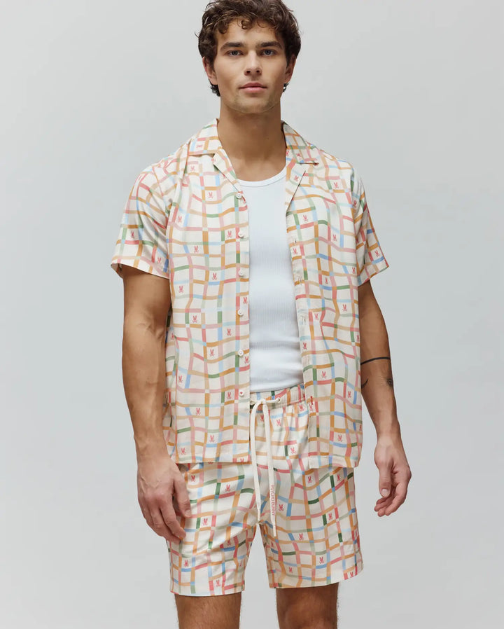 Mens Atlas Tencel Shirt, relaxed fit, off-white with a multicolor pastel grid pattern and repeated small Psycho Bunny skull logos. Matching shorts with Psycho Bunny drawstring.