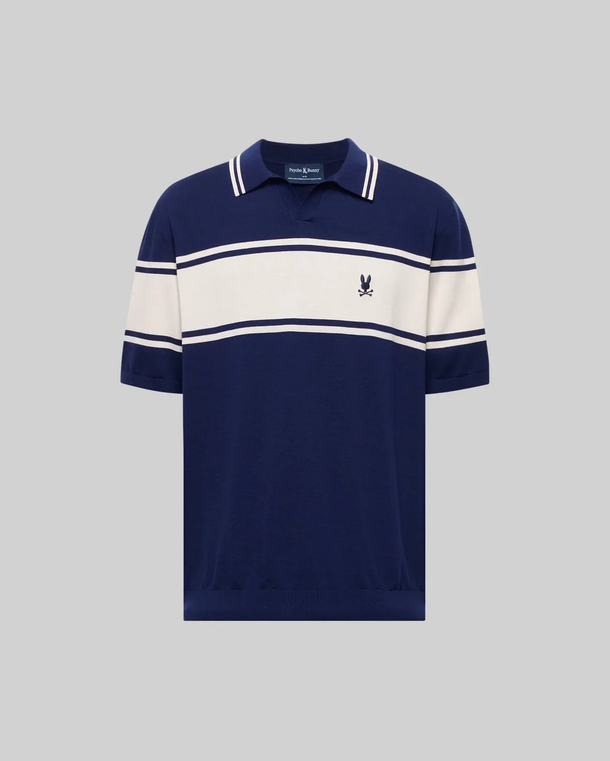 The Psycho Bunny MENS ZAVIAN STRIPE KNIT POLO (MT0400055) features navy blue cotton fabric, white horizontal chest and sleeve stripes, a collar, and a small embroidered logo on the left chest, shown on a plain gray background.