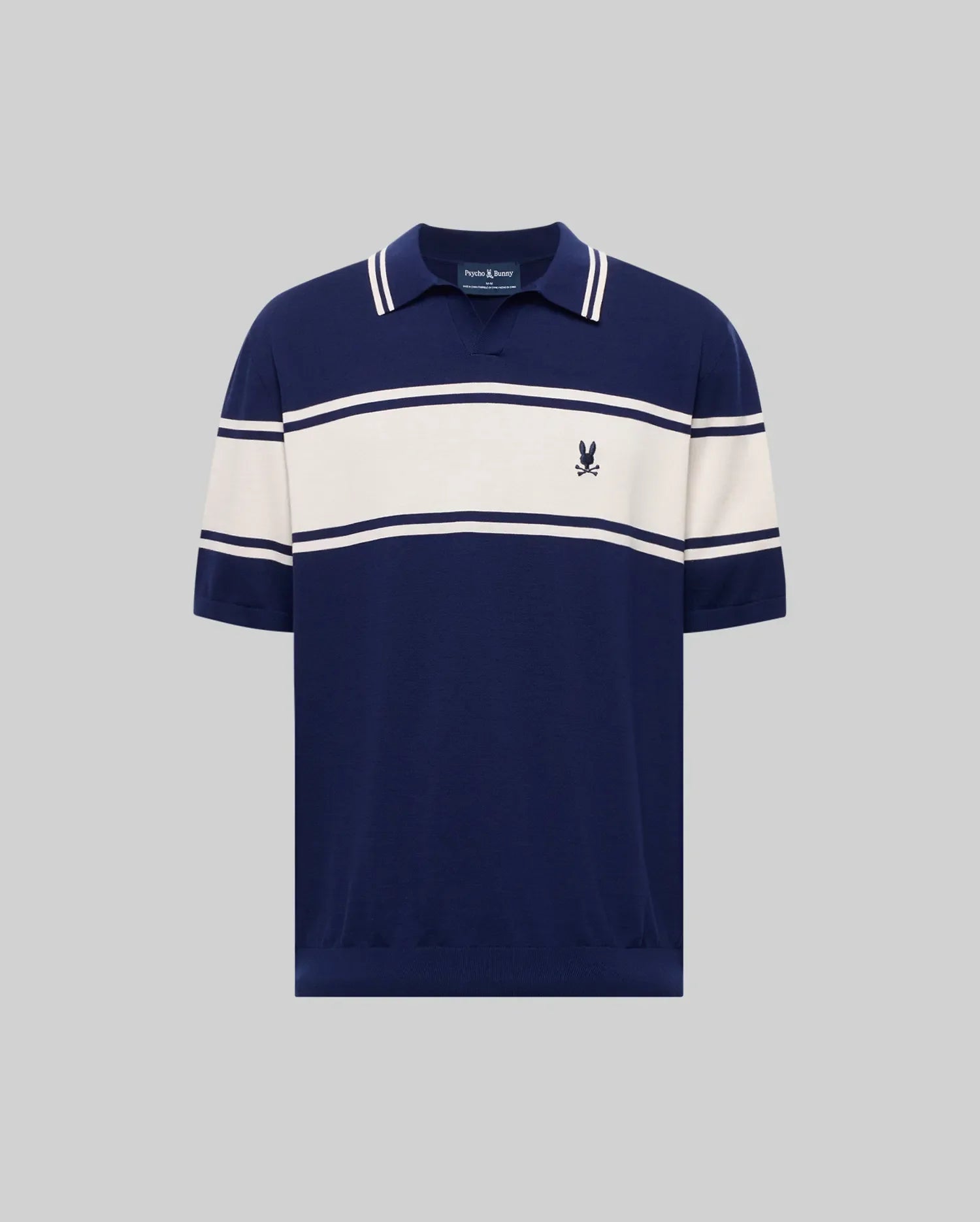 The Psycho Bunny MENS ZAVIAN STRIPE KNIT POLO (MT0400055) features navy blue cotton fabric, white horizontal chest and sleeve stripes, a collar, and a small embroidered logo on the left chest, shown on a plain gray background.