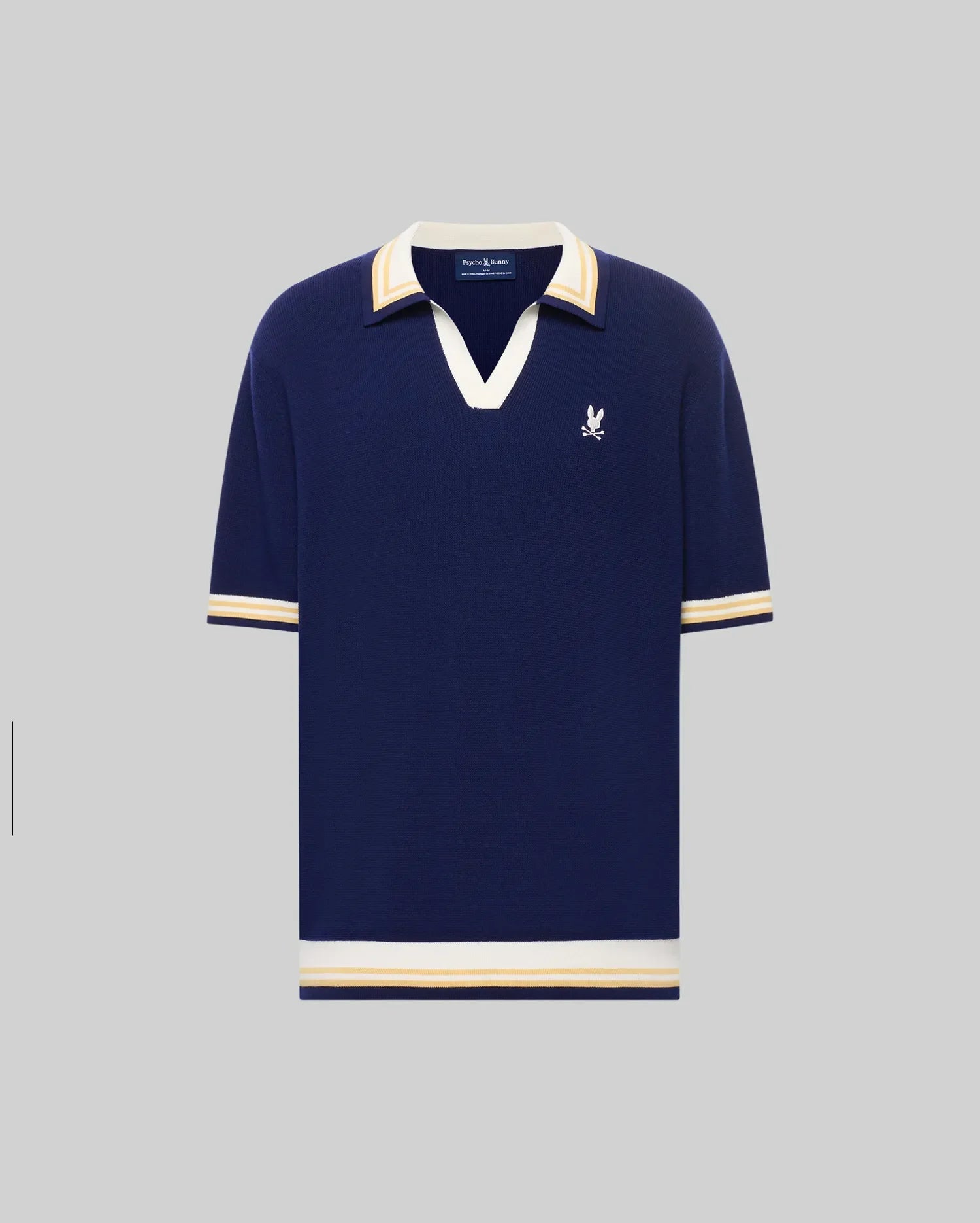 The Psycho Bunny MENS CARTER JOHNNY COLLAR KNIT POLO (MT0400093) is a navy blue cotton short-sleeve shirt with white and beige striped collar, cuffs, and hem, plus a white embroidered bird logo on the left chest. Regular fit.