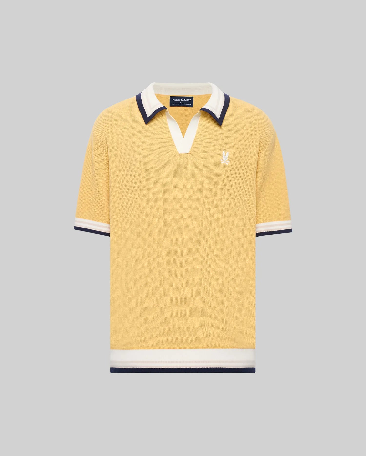 The Psycho Bunny MENS CARTER JOHNNY COLLAR KNIT POLO (MT0400093) is a yellow short-sleeve 100% cotton shirt with a white and navy Johnny collar, chest logo embroidery, and matching sleeve and hem trim, shown on a gray background.