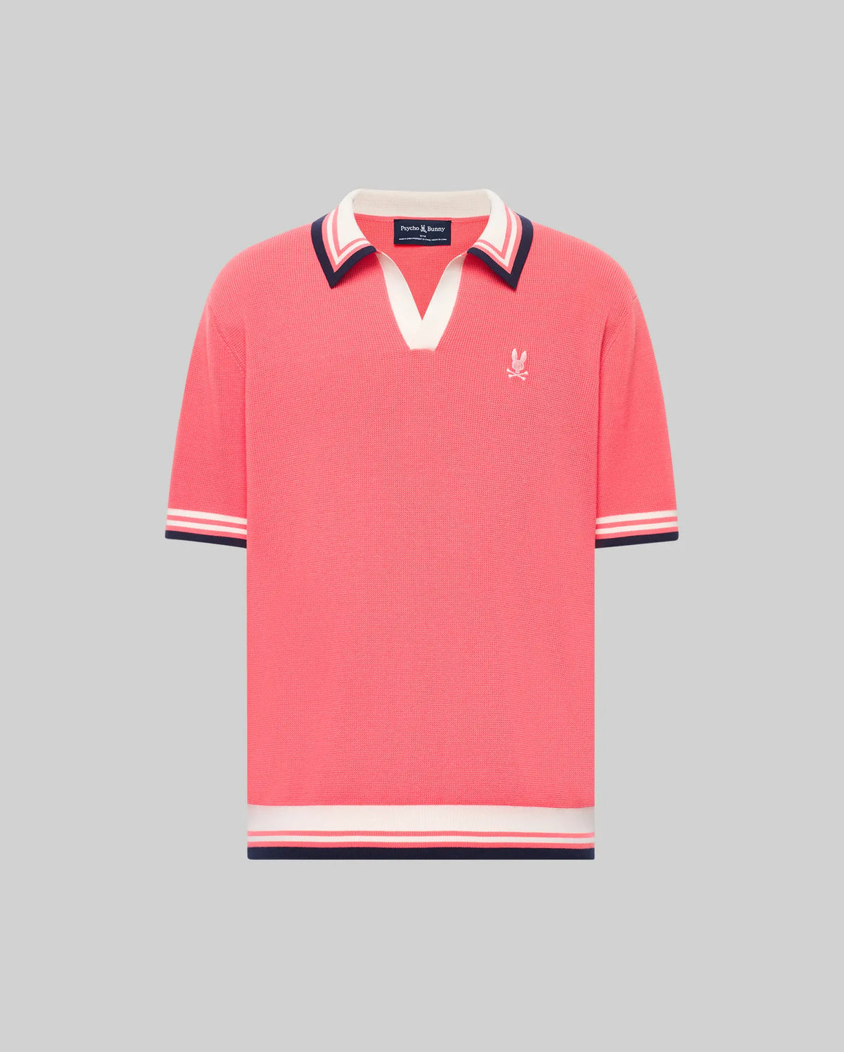 The Psycho Bunny MENS CARTER JOHNNY COLLAR KNIT POLO (MT0400093) is a coral pink, short-sleeved 100% cotton shirt featuring a V-neck Johnny collar, striped cuffs in white, navy, and red, and a small white logo on the left chest.